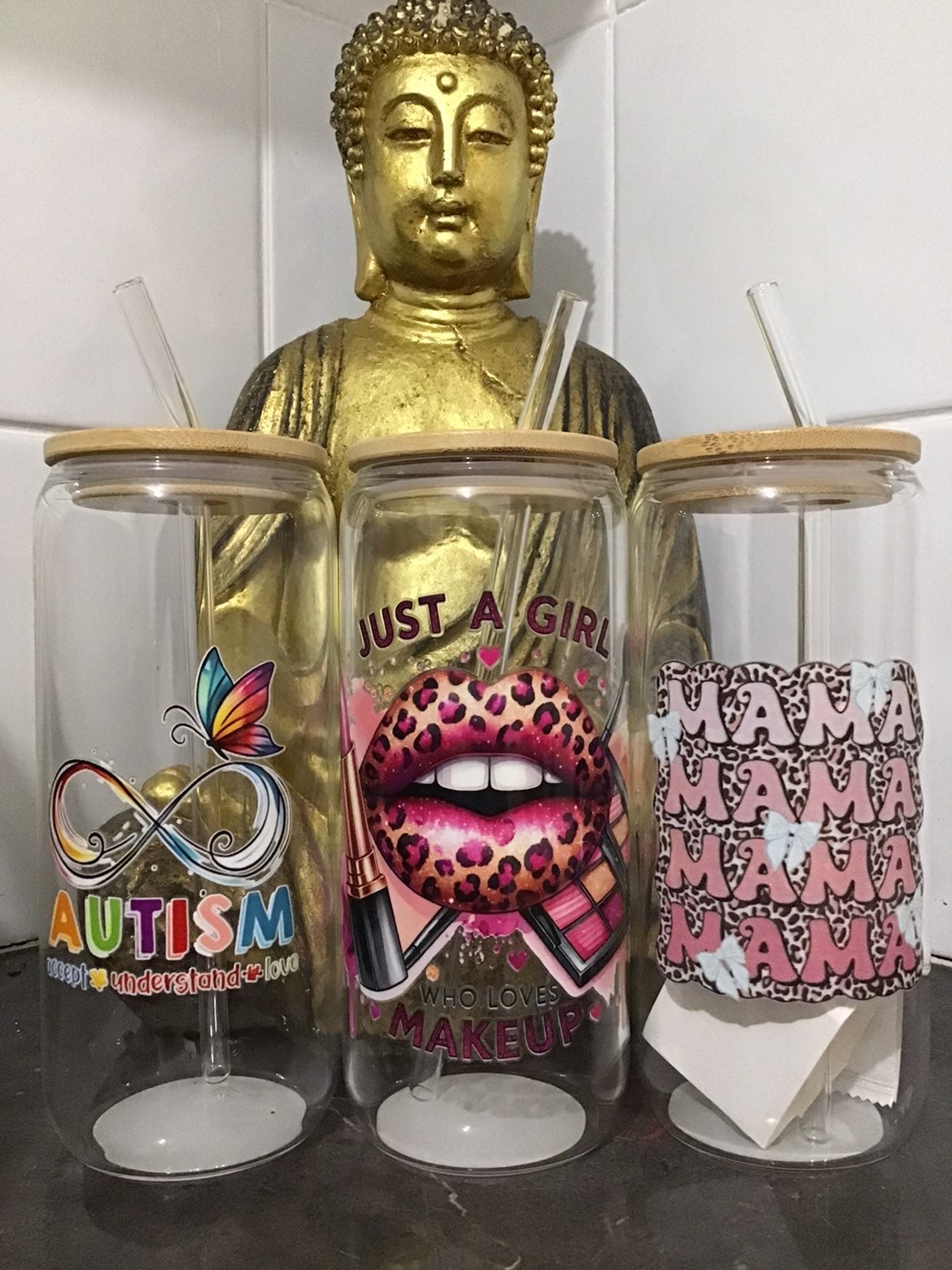 Three tumbler glasses with different designs on a reflective surface.